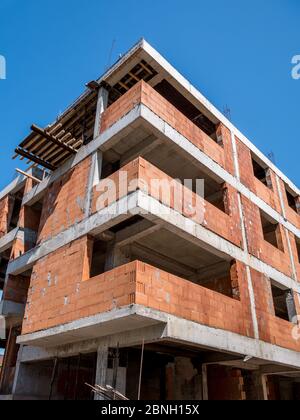 Apartmentgebäude im Bau. Unvollendete Konstruktion Gebäude gegen blauen Himmel. Stockfoto