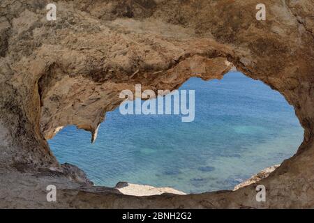 Tunnel durch eine große Vulkangestein namens 'Kalikatsou" über Petra Beach, Patmos, Dodekanes, Griechenland, August 2013 abgetragen. Stockfoto