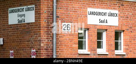 15. Mai 2020, Schleswig-Holstein, Lübeck: Über den Fenstern eines temporären Alternativgebäudes hängen Schilder mit der Aufschrift "Landgericht Lübeck, Saal A". Das Hauptgebäude wird bis mindestens 2021 renoviert und ist daher geschlossen. Foto: Markus Scholz/dpa Stockfoto