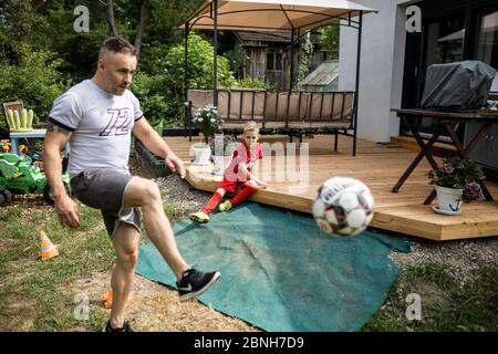 Köln, Fühlingen, 09.05.2020: Bilderstrecke: Vater und Sohn beim kicken im Garten. Stockfoto