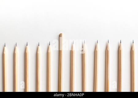 Schöne fein säuberlich geschärfte Bleistifte aus Holz liegen in seltener Reihe Stockfoto