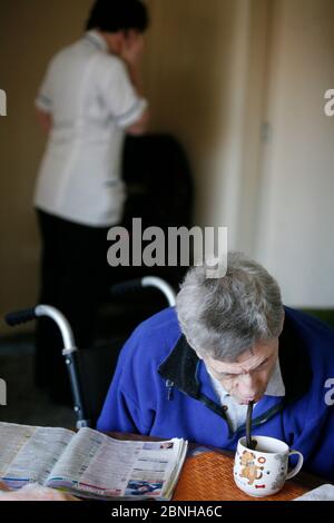 Care Watch Mitarbeiterin Sandra mit Kunde Rodney Milne zu Hause. Stockfoto