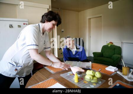 Care Watch Mitarbeiterin Sandra mit Kunde Rodney Milne zu Hause. Stockfoto