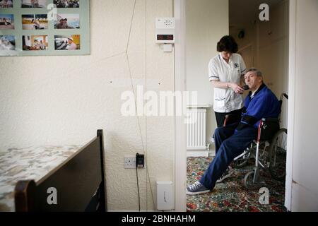 Care Watch Mitarbeiterin Sandra mit Kunde Rodney Milne zu Hause. Stockfoto