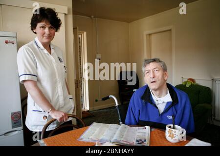 Care Watch Mitarbeiterin Sandra mit Kunde Rodney Milne zu Hause. Stockfoto