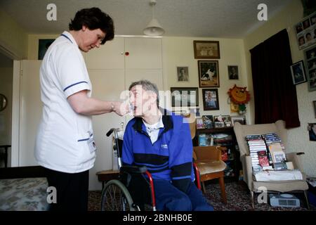 Care Watch Mitarbeiterin Sandra mit Kunde Rodney Milne zu Hause. Stockfoto