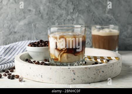 Komposition mit Tablett mit Eiskaffee auf Holzhintergrund Stockfoto