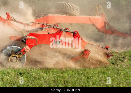 Die landwirtschaftliche Ausrüstung zerschneidet das gepflügte Land. Ein Raupentraktor zieht eine Egge, um den Boden aus der Nähe zu lösen 2021. Stockfoto