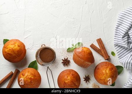 Komposition mit Muffins und Zimt auf weißem Hintergrund Stockfoto