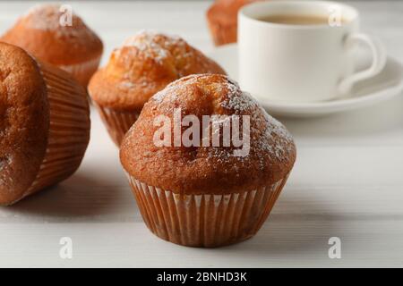 Leckere Muffins und Kakao-Getränk auf weißem Holzhintergrund Stockfoto