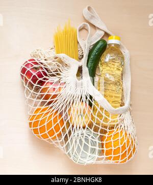 Lieferung von Lebensmitteln. Das Öko-Tütennetz mit Nahrung für Spenden während der Quarantäne. Stockfoto