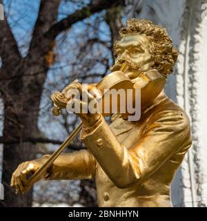 Vergoldete Bronzestatue von Johann Strauss, der am 15. Juli 2018 im Stadtpark in Wien Geige spielt. Strauss war österreichischer Komponist Stockfoto