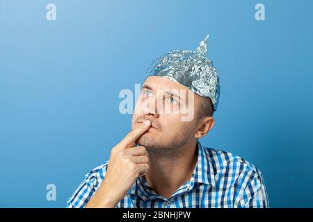 Folienhut auf Mann. Mann mit einem nachdenklichen Gesicht. Schützt vor dem Lesen denken. Stockfoto