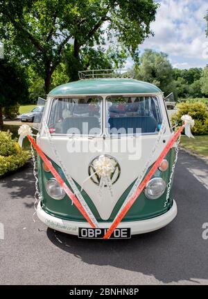 Eine Trauung in Surrey mit Transport von 'Split Dreams'. Der luxuriöse VW-Wohnmobil Typ 2 von Volkswagen transportiert die glückliche Braut und den Bräutigam Stockfoto