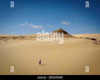 Eine Frau, die einen Spaziergang in der spektakulären Landschaft Wüste in der Nähe von Siwa, Ägypten Stockfoto