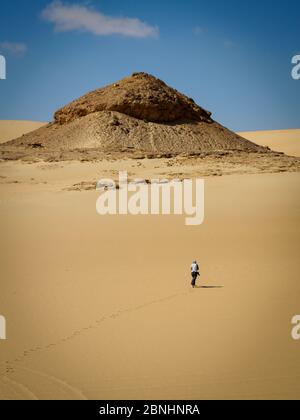 Siwa, Ägypten, eine Frau, die in den Sanddünen der Wüste spazierengeht Stockfoto