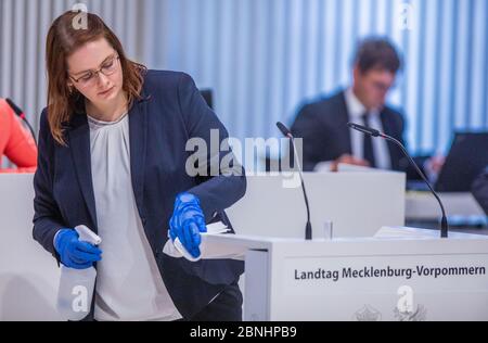 Schwerin, Deutschland. Mai 2020. Ein Mitarbeiter des Landtags reinigt das Rednerpult während der Landtag-Sitzung. Quelle: Jens Büttner/dpa-Zentralbild/ZB/dpa/Alamy Live News Stockfoto