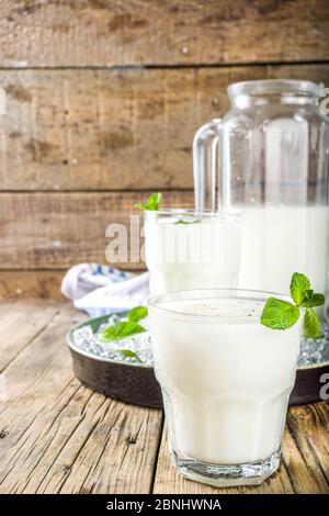 Kaltes indisches Getränk Lassi, eisgekühltes Kokosnuss Lassi-Getränk mit Minzblatt, Holzhintergrund Kopierraum Stockfoto