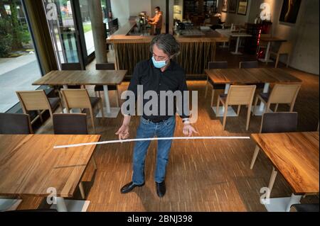 Stuttgart, Deutschland. Mai 2020. Rosario Lamattina misst den Abstand zwischen zwei Tischen in seinem Restaurant 'Perbacco'. Nach einer obligatorischen Corona-Pause von Wochen kann das Restaurant im Südwesten am 18. Mai zumindest teilweise wieder in Betrieb gehen. (Zur dpa 'ab Montag öffnet die Gastronomie - aber wie?') Quelle: Marijan Murat/dpa/Alamy Live News Stockfoto