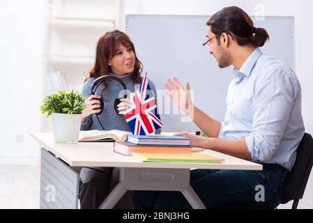 Junger Schüler und männlicher englischlehrer im Klassenzimmer Stockfoto