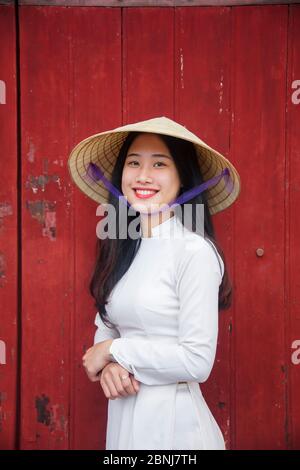 Eine junge Vietnamesin traditioneller Kleidung steht am westlichen Tor zur Purple Forbidden City, Hue, Vietnam, Indochina, Südostasien, A Stockfoto
