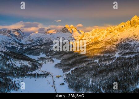Panorama-Blick per Drohne auf die Gipfel der drei Zinnen von Lavaredo und der Cadini di Misurina bei Sonnenuntergang im Winter, Dolomiten, Belluno, Venetien, Italien, Europa Stockfoto