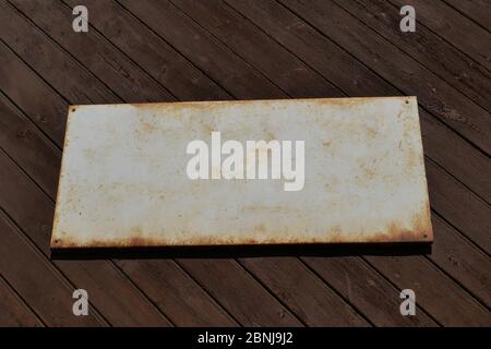 Altes Zinnschild für Textvorlage an einer alten Holzwand. Stockfoto