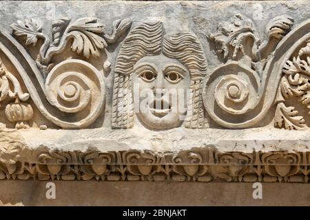 Fragment der Fassade mit dem Bild der Steinmasken des griechisch-römischen Amphitheaters der antiken Stadt Myra in Demre, Provinz Antalya, Türkei Stockfoto