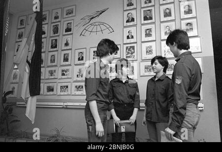 30. November 1987, Sachsen, Belgern: Schüler in FDJ-Kleidung der Juri-Gagarin-Oberschule Blegern (bei Torgau) stehen Ende der 1980er Jahre im Kosmonauten-Club vor einer Wand mit Porträts sowjetischer Kosmonauten. Das genaue Datum des Fotos ist nicht bekannt. Foto: Volkmar Heinz/dpa-Zentralbild/ZB Stockfoto