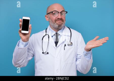 Reifen männlichen Arzt zeigt leeren Bildschirm des Smartphones. Stockfoto