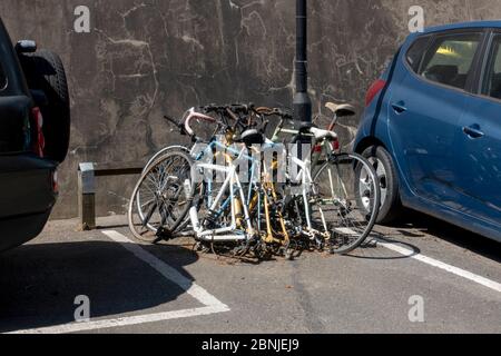 Eine Reihe von fünf Fahrrädern, die am 15. Mai 2020 in West Norwood, South London, England an einen Lampenstegplatz auf einem Parkgelände gekettet wurden. Stockfoto