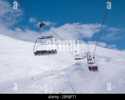 PARNASSOS, GRIECHENLAND - 5. JANUAR 2019: Parnassos Berg mit Schnee und Menschen auf der Piste an einem sonnigen Tag Stockfoto