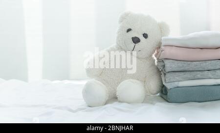 Flauschige weiße Bär Puppe mit weichen bequemen rosa grau blau Stoff Tuch Stapel weiß gemütliches Licht Heim Innen Web-Design Banner Hintergrund Stockfoto