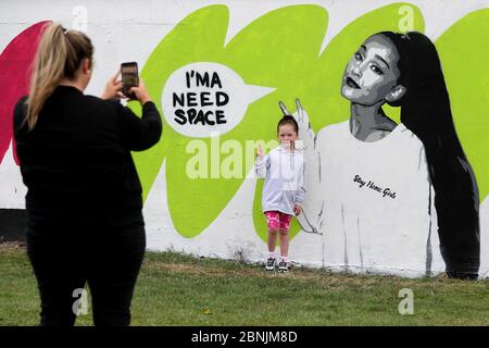 Michelle Lyons fotografiert ihre Tochter Lauren Ryan (5) mit der irischen Künstlerin Emmalene Blake auf dem Wandgemälde von Ariana Grande in Süd-Dublin. Dies ist das jüngste in der Serie 'Stay at Home' des Dubliner Künstlers, der die Menschen dazu ermutigt, sich an soziale Distanzierungen zu halten. Weitere Künstler waren Dua Lipa, Tia und Tamera Mowry, Cardi B, Robyn, The Police, Ice Cube, Pinky and the Brain und David Bowie. Siehe PA Geschichte GESUNDHEIT Coronavirus Irland. Das Foto sollte lauten: Brian Lawless/PA Wire Stockfoto