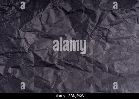 Dunkle zerknitterte gefaltet schwarzen Papier Poster Textur. Unbeschriftete zerknitterte, körnige Papieroberfläche. Verschmierter, munziger Karton mit Faser. Nahaufnahme. Stockfoto