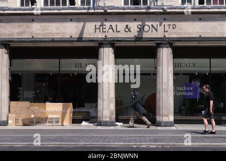 Menschen, die vor einem Möbelhaus in der Tottenham Court Road, London, an einem Obdachlosenheim aus Pappe vorbeigehen, nachdem Maßnahmen eingeleitet wurden, um das Land aus der Blockade zu bringen. Stockfoto