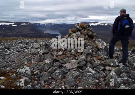 Mann Wanderer Blick auf Loch an t-Seilich in Glen Tromie vom Gipfel des schottischen Berges Corbett Meallach Mhor, Scottish Highlands, Schottland, Großbritannien Stockfoto