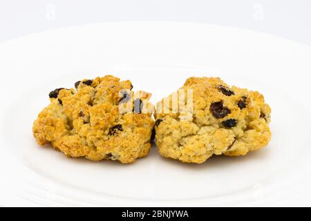 Zwei frisch zubereitete traditionelle köstliche goldene hausgemachte Steinkuchen präsentiert auf einem weißen porzellangeeller mit weißem Hintergrund Stockfoto