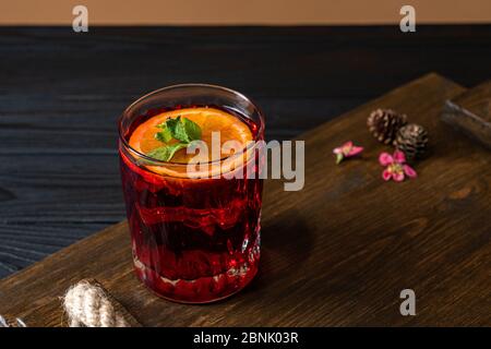 Köstlicher Alkoholcocktail auf einem Holztablett, rote Cocktails, Cocktails mit Früchten, Cocktail mit Limette, exotisches Getränk Stockfoto