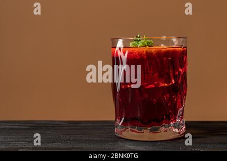 Glas Rum auf dem Holztisch, Cuba Libre oder Long Island Eistee Cocktail mit starken Getränken und Orangenscheiben Stockfoto