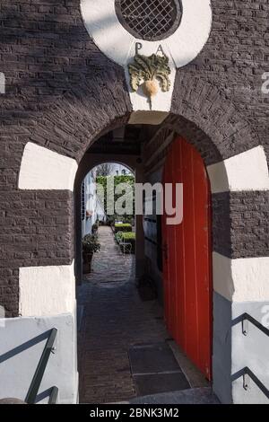 Amsterdam, Niederlande - April 2017: Ein dezentes altes Tor und Tor führt zu einem ruhigen Amsterdamer Innenhof Stockfoto