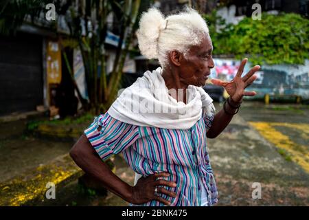 Eine afro-kolumbianische Obstverkäuferin spricht über ihre Arbeit auf dem Flussmarkt in Quibdó, Chocó, dem pazifischen Departement Kolumbiens. Stockfoto