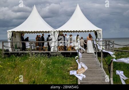 15. Mai 2020, Schleswig-Holstein, Stein: Die 23-jährige Lisann Camara wird von ihrem Cousin Konstantin am Strand der Kieler Förde zu ihrer Hochzeitszeremonie begleitet. Familienfeiern sind aufgrund der Koronakrise nur bedingt möglich. Foto: Axel Heimken/dpa Stockfoto