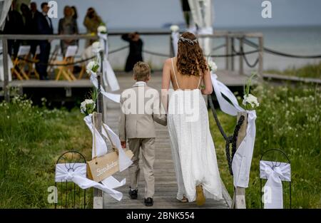 15. Mai 2020, Schleswig-Holstein, Stein: Die 23-jährige Lisann Camara wird von ihrem Cousin Konstantin am Strand der Kieler Förde zu ihrer Hochzeitszeremonie begleitet. Familienfeiern sind aufgrund der Koronakrise nur bedingt möglich. Foto: Axel Heimken/dpa Stockfoto