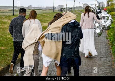 15. Mai 2020, Schleswig-Holstein, Stein: Hochzeitsgäste verlassen die Feierlichkeiten nach einer Trauung am Kieler Förde-Strand bei strömendem Regen. Familienfeiern sind aufgrund der Koronakrise nur bedingt möglich. Foto: Axel Heimken/dpa Stockfoto