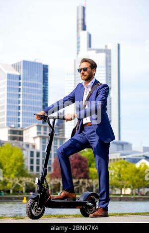 Mann im Anzug auf einem E-Scooter Stockfoto
