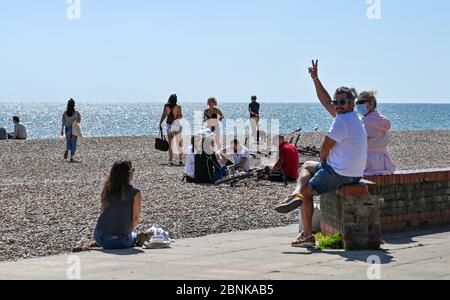 Brighton UK 15. Mai 2020 - Menschen unter 30 Jahren versammeln sich am Strand von Brighton und am Meer an einem sonnigen Tag an der Südküste. Allerdings hoffen die Abgeordneten von Brighton, dass die Massen an diesem Wochenende nicht an der Küste absteigen, nachdem die Regierungen die Beschränkungen der Lockdown in England während der COVID-19-Pandemie leicht gelockert hatten. Quelle: Simon Dack / Alamy Live News Stockfoto