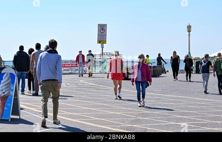 Brighton UK 15. Mai 2020 - Menschen versammeln sich an der Küste von Brighton an einem sonnigen Tag an der Südküste. Allerdings hoffen die Abgeordneten von Brighton, dass die Massen an diesem Wochenende nicht an der Küste absteigen, nachdem die Regierungen die Beschränkungen der Lockdown in England während der COVID-19-Pandemie leicht gelockert hatten. Quelle: Simon Dack / Alamy Live News Stockfoto