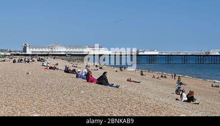 Brighton UK 15. Mai 2020 - Menschen versammeln sich am Strand und am Meer von Brighton an einem sonnigen Tag an der Südküste. Allerdings hoffen die Abgeordneten von Brighton, dass die Massen an diesem Wochenende nicht an der Küste absteigen, nachdem die Regierungen die Beschränkungen der Lockdown in England während der COVID-19-Pandemie leicht gelockert hatten. Quelle: Simon Dack / Alamy Live News Stockfoto