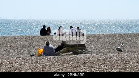 Brighton UK 15. Mai 2020 - Menschen versammeln sich am Strand und am Meer von Brighton an einem sonnigen Tag an der Südküste. Allerdings hoffen die Abgeordneten von Brighton, dass die Massen an diesem Wochenende nicht an der Küste absteigen, nachdem die Regierungen die Beschränkungen der Lockdown in England während der COVID-19-Pandemie leicht gelockert hatten. Quelle: Simon Dack / Alamy Live News Stockfoto